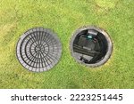 Small photo of Image of a compact septic tank grease trap for home use to help collect light liquids such as fats, oils, and grease from the kitchen buried underground with green grass cover.