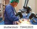 Smart precision healthcare technology , artificial intelligence concept. Automation robot hand machine in operating room and surgery doctors in futuristic hospital.