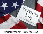 Veterans day 11th November. Veterans day. Honoring all who served. Printed on sheet of paper. American (USA) flag on wooden background.
