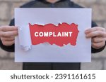 Small photo of Man holding red and white sheets of paper with word: COMPLAINT. Concept of complaints. Customer complaint, dissatisfaction from product or service problem, angry feedback from client.