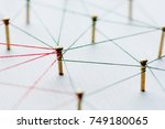 Small photo of Background. Abstract concept idea of network, social media, internet, teamwork, communication. Thumbtacks linked together by red thread. Isolated. Entities connected.