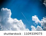 Plane In Blue Sky With Clouds