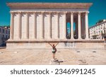 Small photo of Woman traveling in France, Maison carree in Nimes city- tour tourism, travel,vacation concept