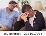 Small photo of frustrated, young man is sitting at home on couch. difficult teenager covers his face with his hands, he has problems. father talks to his son, discusses problems, supports him. Transitional age