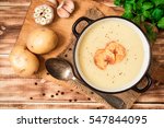 Homemade potato cream soup with potato chips on wooden table