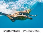 Snorkeling with a sea turtle. Girl swimming with a mask next to the turtle, Maldives