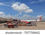 Small photo of Chiangmai, Thailand. August 8, 2017. Thai Lion Air Boeing 737 Parking at Gate Terminal for Boarding Passenger by Jet Bridge with Baggage car Foreground at Chiangmai International Airport.