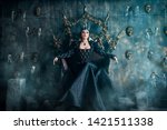 Small photo of Evil Queen in a black dress. Beautiful girl in the crown sits on the throne
