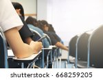 Hands university student holding pen writing /calculator doing examination / study or quiz, test from teacher or in large lecture room, students in uniform attending exam classroom educational school.