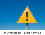 Exclamation mark on a yellow road sign. Against the blue sky Warning, danger, attention