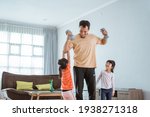 Small photo of kid disturb his daddy while doing sport at home