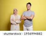 hijab women and men smiling crossed arms looking at camera isolated on a yellow background