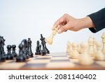Small photo of Hand holding king to knock down king while playing chess