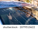 Shocked woman in car with broken windshield  and cracks. Car accident. Selective focus