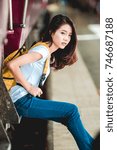 Small photo of Teen Asian girl waiting for checked baggage train platform area prepared to ready to go sightseeing by the provinces in the country, Thailand on weekends.