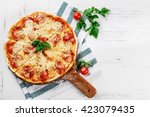 Hot true PEPPERONI ITALIAN PIZZA with salami and cheese. TOP VIEW Tasty traditional pepperoni pizza on board on white wooden table with decoration. Copy space for your logo. Ideal for commercial 