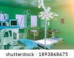 Small photo of Interior of operating theatre with green walls for birthing of pregnant women, birth Surgery, natural birth, giving birth with caesarian operation. Modern equipment in operating room. Nobody.