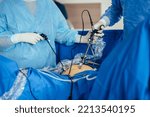Small photo of Gynecological treatment of the patient in surgery room. Laparoscopic surgery, gynecology. Close up of surgeon hands during operation receiving assistance from nurse.