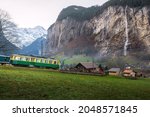 Train in Lauterbrunnen Valley with waterfalls on background - Lauterbrunnen, Switzerland
