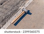 Small photo of An iron sledgehammer with a wooden handle is lying on the sidewalk