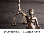 Small photo of The Statue of Justice - lady justice or justitia the Roman goddess of Justice. Statue on black wooden wall. Concept of judicial trial, courtroom process and lawyers occupation