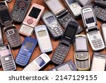 Small photo of KHARKIV, UKRAINE - DECEMBER 16, 2021: Some old used outdated mobile phones from 90s-2000s period. Recycling electronics in the market cheap