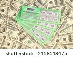 Small photo of Close up view of green lottery scratch cards and us dollar bills. Many used fake instant lottery tickets with gambling results. Gambling addiction concept.