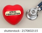 Small photo of Medicine concept. Near the stethoscope lies a heart on which a sticker is pasted with the inscription - Atrial Fibrillation