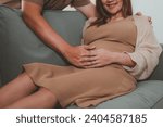 Small photo of mother, family, maternity, pregnant, woman, pregnancy, baby, motherhood, love, happiness. close up of happy pregnant newbie mother with big belly and newbie father embrace to her belly near sofa.