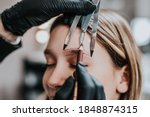 Small photo of Cosmetologist measures the proportions of the eyebrows with the ruler. Micropigmentation work flow in a beauty salon.