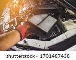 Mechanic hand is replacement car air filter into the filter socket of a car engine,Automotive part concept.