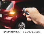 Human hand is pressing lock or unlock button of the car keyless remote