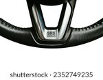 Small photo of SRS Supplemental Restraint System Airbag symbol on leather steering wheel of a car, close up of SRS Airbag banner with silver colour on white background, Automotive parts concept