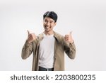 Small photo of Portrait handsome asian man happy in a casual outfit, with his both hands showing thumbs up along with a cheerful smile on his face, giving the positive energy on isolated white background.