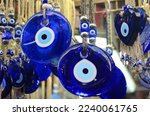 Nazar in market. Blue and red Fatima eye close-up protective amulet against evil eye. Israeli and turkish souvenir. decorative glass blue souvenirs in the form of an eye