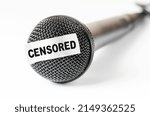 Small photo of The microphone is sealed with sticky tape. The concept of restricting freedom of speech or obscene language. Closeup, white background.