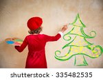 Child painting Christmas decorations. Kid playing at home. Xmas holiday concept