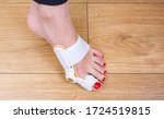 Small photo of Woman uses a special medical splint or orthopedic holder to treat and prevent painful Hallux Valgus. Bunion on big toes of female feet.