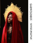 Small photo of Black skin woman dressed in a red clothes/ fabric with golden aureole, praying