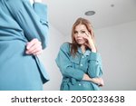Small photo of Close-up indoor portrait of a young beautiful woman in business style outfit looking to her own reflection in the mirror. Selfie, vanity, conceit, ego, digital narcissism concept minimal design.
