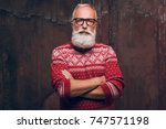 Beautiful senior man bearded in Christmas sweater. Santa Claus wishes Merry Christmas