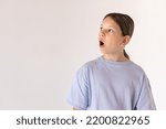 Small photo of Portrait of surprised preteen girl wearing blue T-shirt looking away. Astounded Caucasian child posing against white background. Surprise concept
