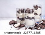 Cream and cookie layered dessert. Homemade oreo trifle, vanilla chocolate cookie layered cheese cake in glass, variation of traditional american breakfast dessert