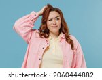 Small photo of Young sad confused ashamed redhead chubby overweight woman 30s in pink shirt casual clothes scratching head look aside oops gesture isolated on pastel blue background studio People lifestyle concept