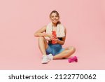 Full size young strong sporty athletic fitness trainer instructor woman wear blue tracksuit spend time in home gym drink water isolated on pastel plain light pink background. Workout sport concept.
