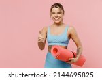 Small photo of Young strong sporty athletic fitness trainer instructor woman wear blue tracksuit spend time in home gym show thumb up gesture isolated on pastel plain light pink background. Workout sport concept.