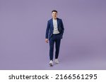 Full size body length happy young successful employee business man lawyer 20s wear formal blue suit white t-shirt work in office move hand in pocket isolated pastel purple background studio portrait