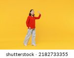 Small photo of Full size body length cheerful young woman of Asian ethnicity 20s in casual clothes look camera go move meet greet waving hand as notices someone isolated on plain yellow background studio portrait
