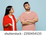 Small photo of Young displeased sad couple two friends family Indian man woman wear red casual clothes t-shirts together scream, arguing, ignoring look aside isolated on pastel plain light blue cyan color background