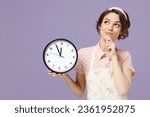 Small photo of Young pensive thoughtful wistful fun housewife housekeeper chef cook baker woman wear pink apron hold clock prop up chin look aside isolated on pastel violet background Cooking food process concept